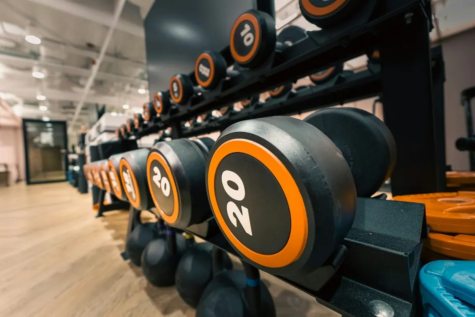 Rack of rubber dumbbells with orange weight numbers
