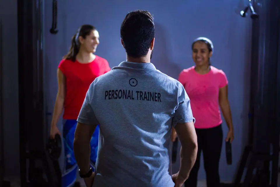 Personal trainer welcoming two women members to a session