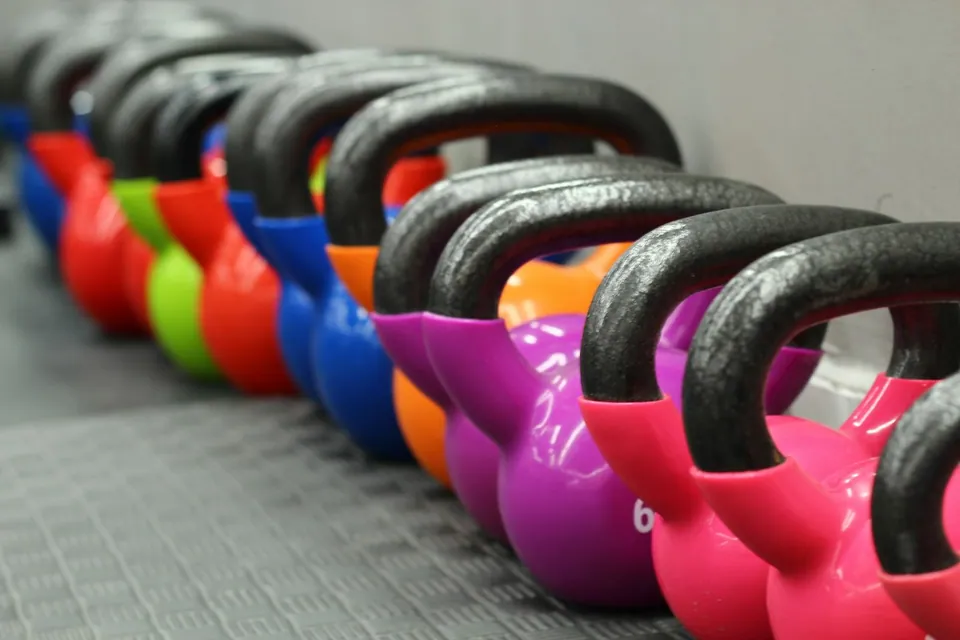 Colourful kettlebells lined up on the gym floor