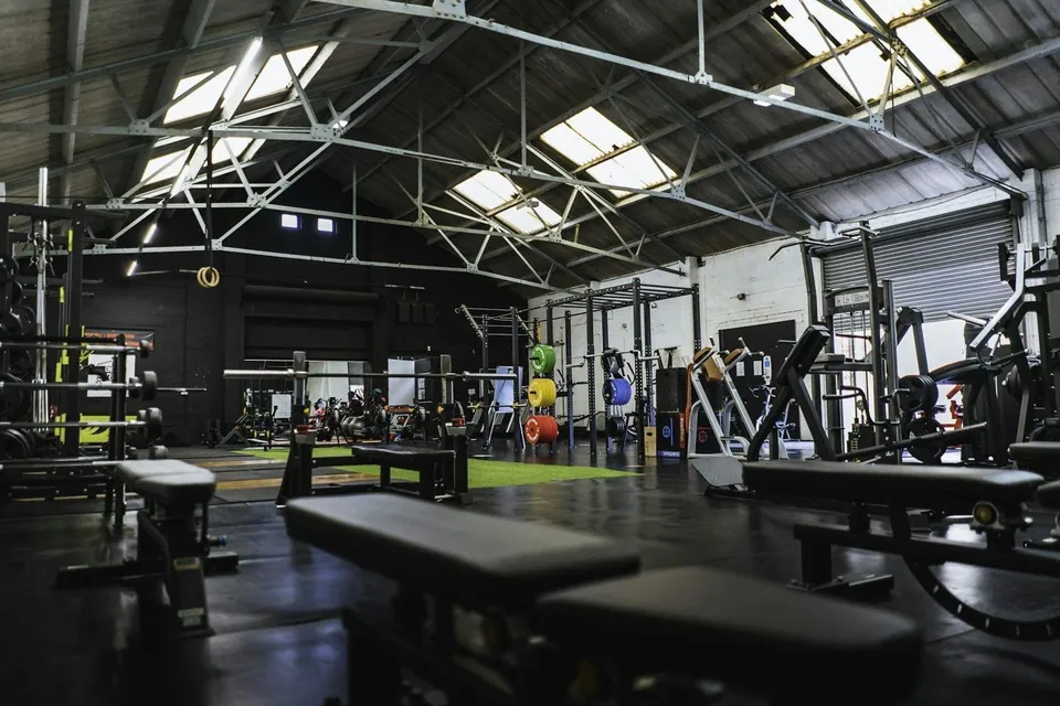 Spacious industrial gym with skylights and weight benches