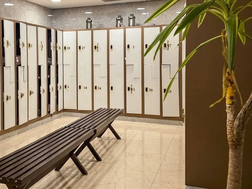 Clean gym locker room with bench and tiled floor